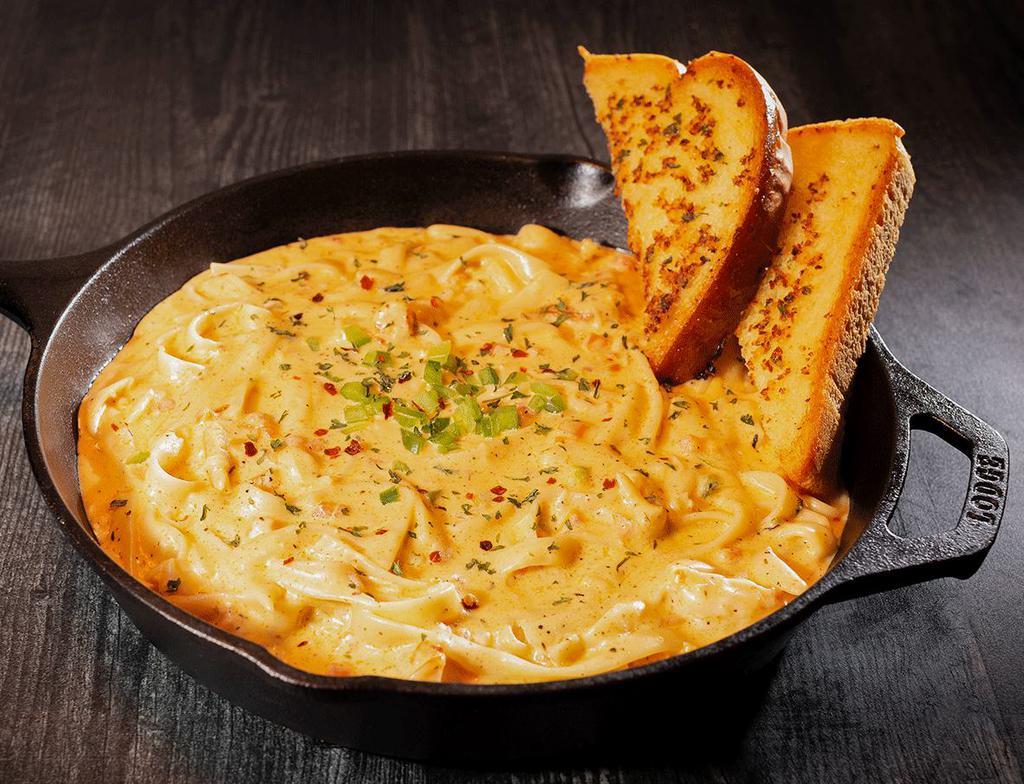 Cajun Chicken Pasta · Creamy fettuccine noodles smothered in our zesty Alfredo sauce with a side of garlic toast. Topped with blackened chicken.