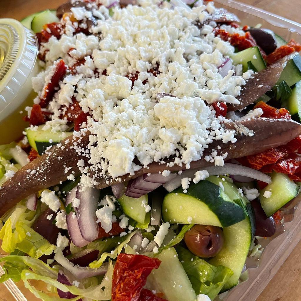 Constantine’s Salad · Cherry tomatoes, cucumbers, lettuce, caper leaves, sun-dried tomatoes, marinated anchovies, olives, onions, the spread of Feta cheese, with Greek virgin olive oil and vinegar.