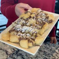 Rotolo alla Nutella · Lightly fried dough topped with Nutella, hazelnuts and honey