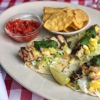 Grilled Fish Tacos   · herb marinated mahi mahi, cabbage salw, cilantro crema, pineapple pico de gallo, chips & sal...