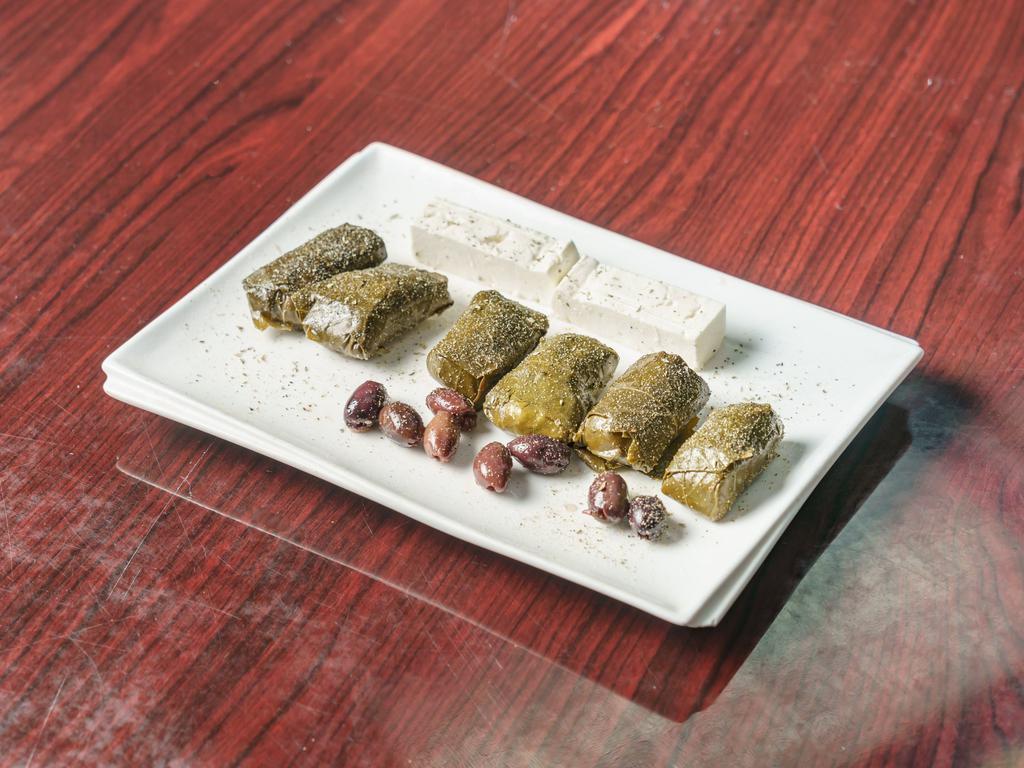 Greek Dolmades · Stuffed grape leaves served with feta cheese and olives.