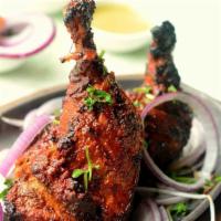Tandoori Chicken (Full) · Grilled bone-in chicken marinated in yogurt, garlic, ginger, ground spices and grilled in Ta...