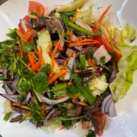 Spicy Beef Salad · Grilled sliced beef, lemongrass, onions, mint leaves and a spicy chili lime dressing.