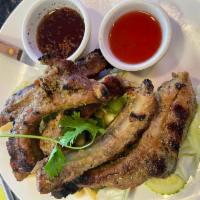 Grilled Pork Ribs · Pork ribs marinated with Thai herbs served with sweet and sour sauce.
