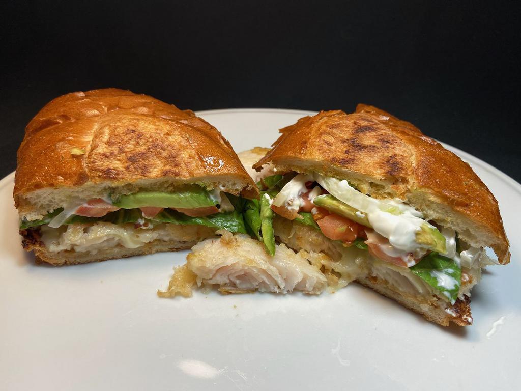 Torta with Fish · Grilled filet of fish in a hot french roll with melted cheese, mayonnaise, sour cream, cheese, tomatoes, onion and avocado.