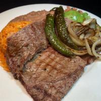 Carne Asada Plate · Top sirloin Steak,served with grilled onions & jalapeño on top.  served with refried beans, ...