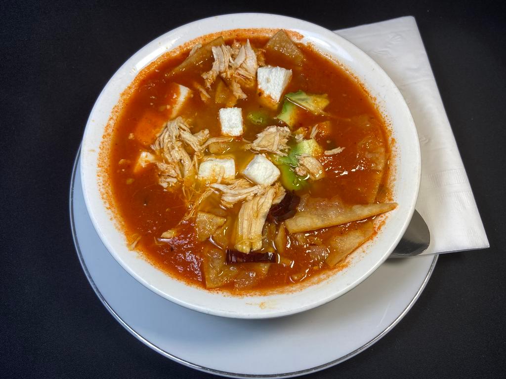 Tortilla soup with Chicken · Chicken with fried pieces of corn tortilla in a chicken & tomato broth topped with avocado, mexican cheese & dry chili pods.