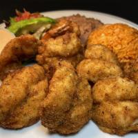 Camarones Empanizados · Nine breaded large  prawns served with refried beans, Mexican rice, salad & avocado slice. Y...