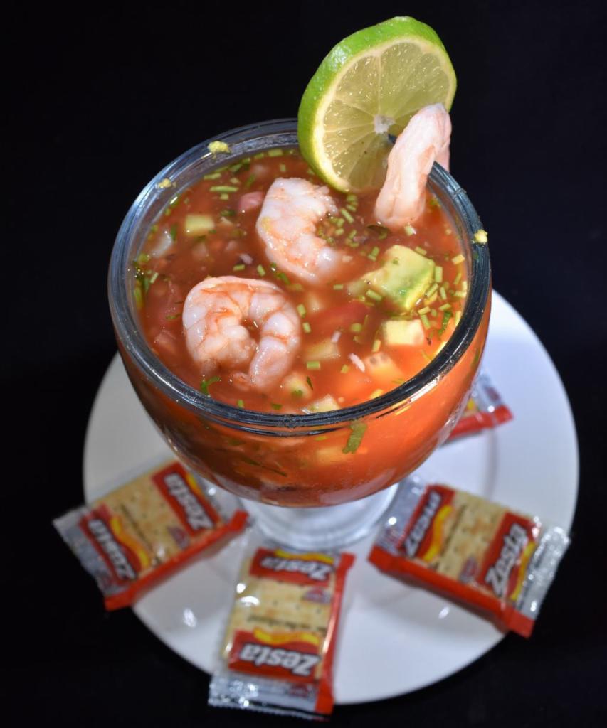 Cocktail de Camarones · Shrimp cocktail, made with Alaskan shrimp, chopped onions, cilantro, tomato, cucumber in a seafood & tomato broth, must taste!! Served with crackers.