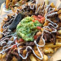 Carne Asada Fries · French fries covered in slow cooked beans, shredded cheddar cheese, seasoned carnes asada st...
