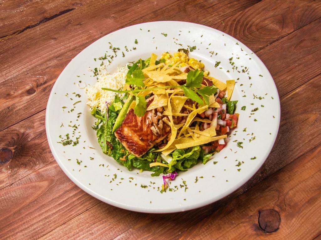 Guadalajara Salmon Salad · A grilled salmon filet laid on a bed of romaine lettuce, red cabbage, carrots, tomatoes, avocado, roasted pecans, shredded cheese and corn tortilla strips with your choice of dressing.