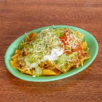 Nachos Super · Corn tortilla chips served with chicken or beef, beans refried or black, lettuce, tomatoes, ...