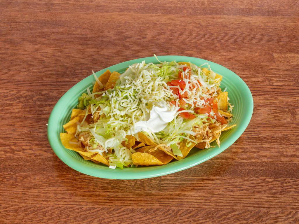 Nachos Super · Corn tortilla chips served with chicken or beef, beans refried or black, lettuce, tomatoes, sour cream, guacamole, and shredded cheese.
