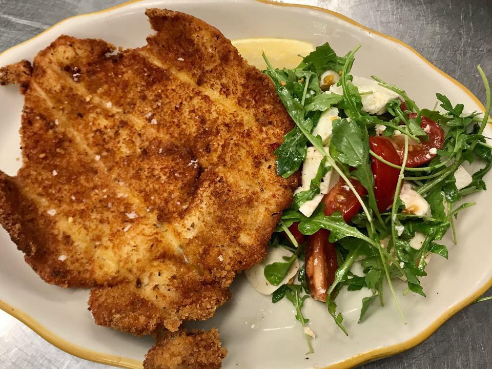 CHICKEN MILANESE · breaded pan fried chicken breast over arugula salad with tomato, mozzarella,  lemon & E.V.O.O.
