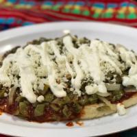 Tlacoyos · Oval shaped masa stuffed with cooked ground beans and cheese. Topped with guajillo pepper sa...
