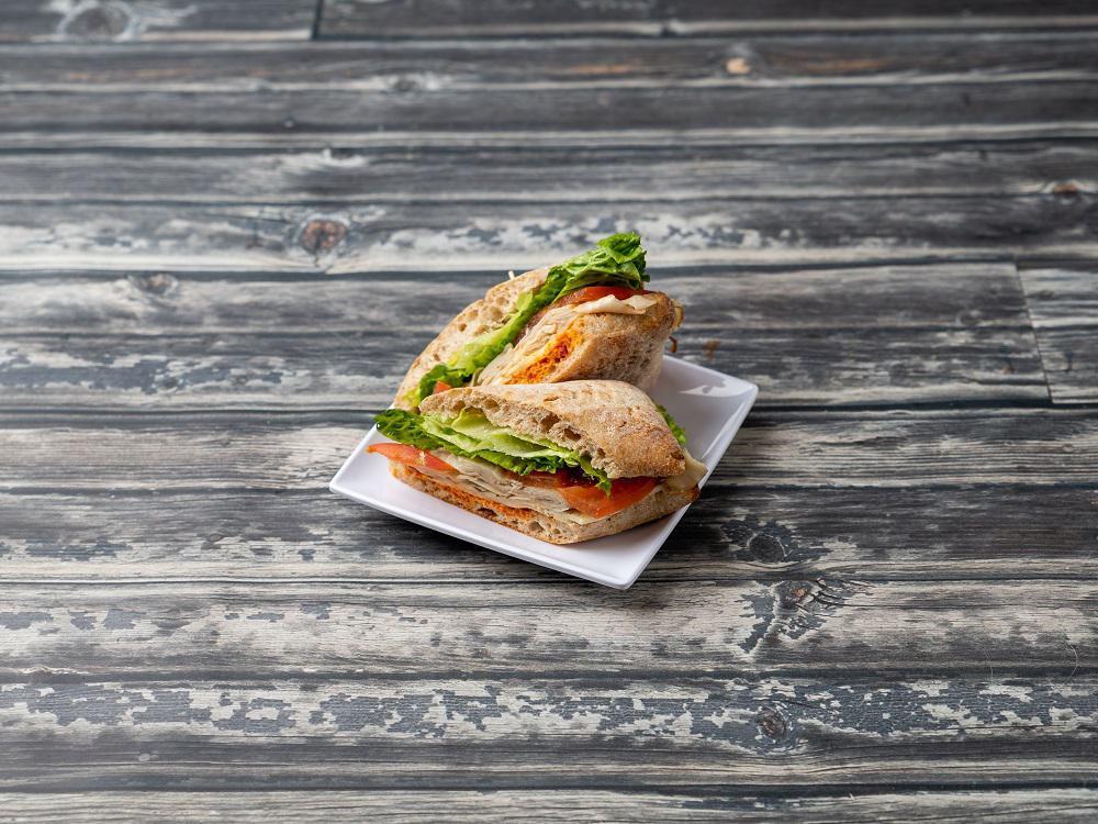 Turkey Sandwich · Turkey, dill Havarti cheese, green leaf lettuce, and sliced tomatoes, served on a whole grain sandwich bun, with Romesco spread and a touch of mayo. Romesco contains almonds.