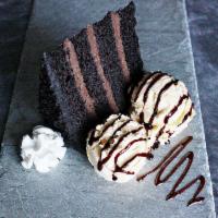 Chocolate Cake a la Mode · Moist multi-layer chocolate cake with decadent fudge icing topped with creamy vanilla ice cr...