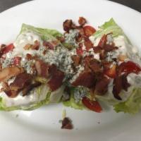 Iceberg Wedge Salad · Crumbled bleu cheese, halved grape tomatoes, crumbled applewood bacon, bleu cheese dressing.