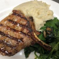 Grilled Double Cut Pork Chop · Tender bone-in 14 oz. pork chop served with sauteed organic baby spinach and mashed potatoes.