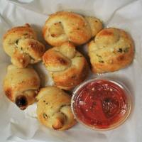 Garlic Knots · Baked knotted dough brushed with garlic butter. Served with marinara.
