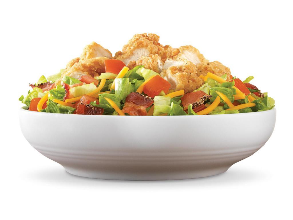 Crispy Chicken Farmhouse Salad · Crispy chicken and diced pepper bacon on a bed of chopped fresh lettuce with diced tomatoes and shredded cheddar cheese. Visit arbys.com for nutritional and allergen information.
