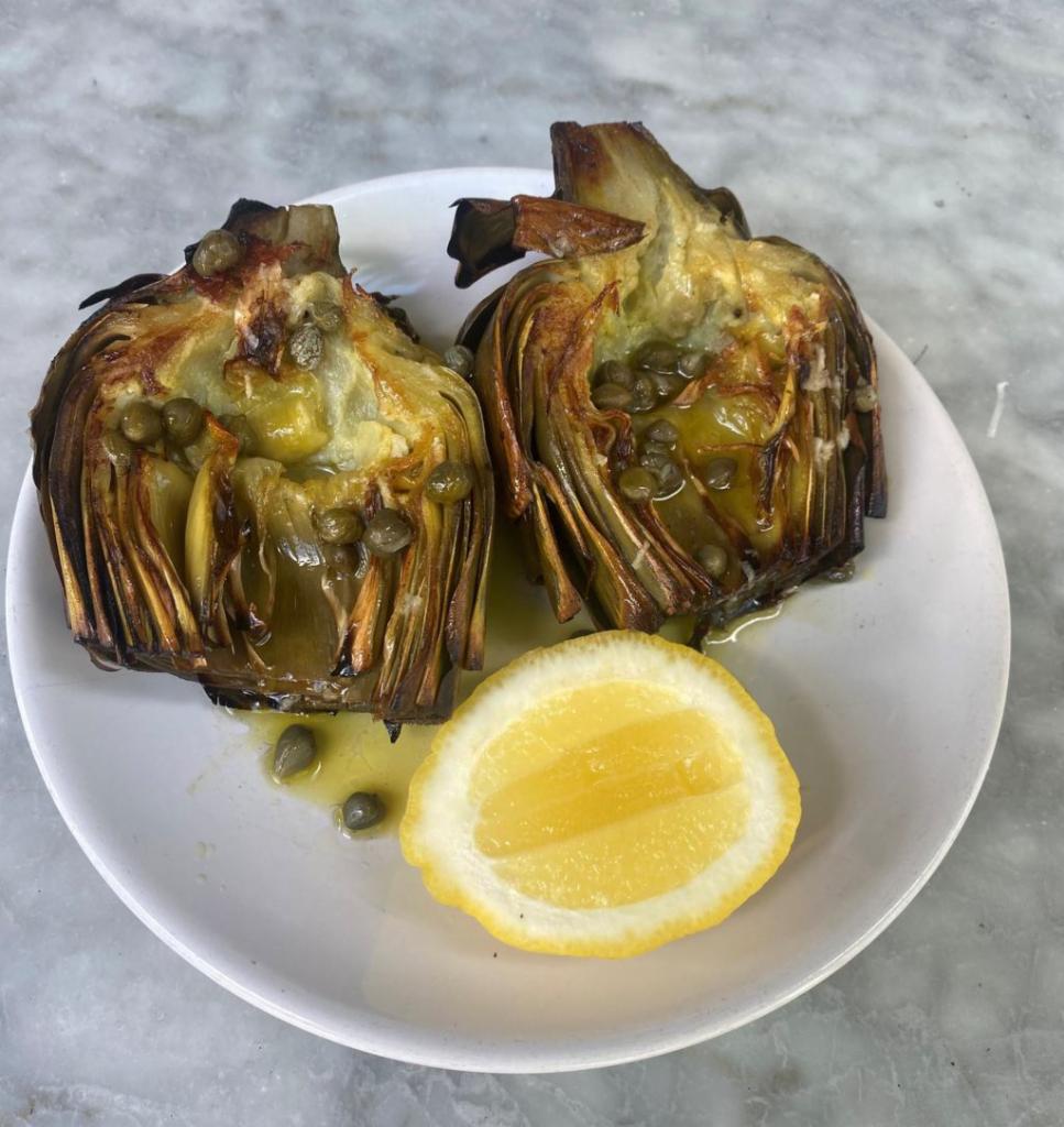 Roasted Artichoke · Whole artichoke clove, cut in half and oven roasted with a lemon-caper vinaigrette and served with a lemon wedge on the side.