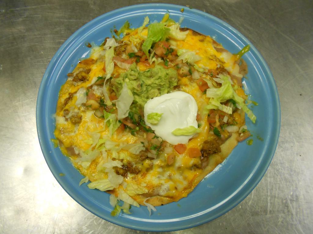 Mexican Pizza · A crisp flour tortilla topped with refried beans, your choice of chicken or ground beef, and melted cheese. Garnished with lettuce, pico de gallo and sour cream. Substitute another meat for an additional charge. Add guacamole for an additional charge.