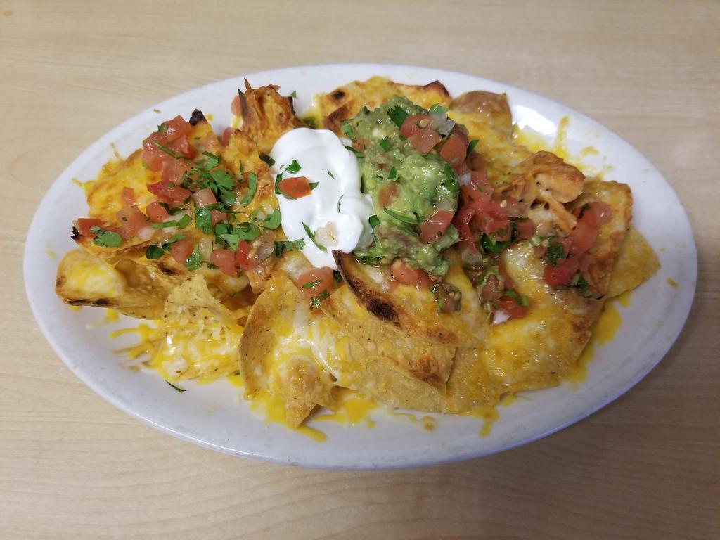 Super Nachos · Crispy corn tortilla chips topped with refried beans your choice of meat, melted cheese garnished with pico de gallo, guacamole, and sour cream. Jalapenos upon request.