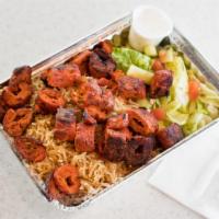Kofta over rice · Two skewers of freshly ground chicken mixed with fresh herbs and spices, cooked on an open f...