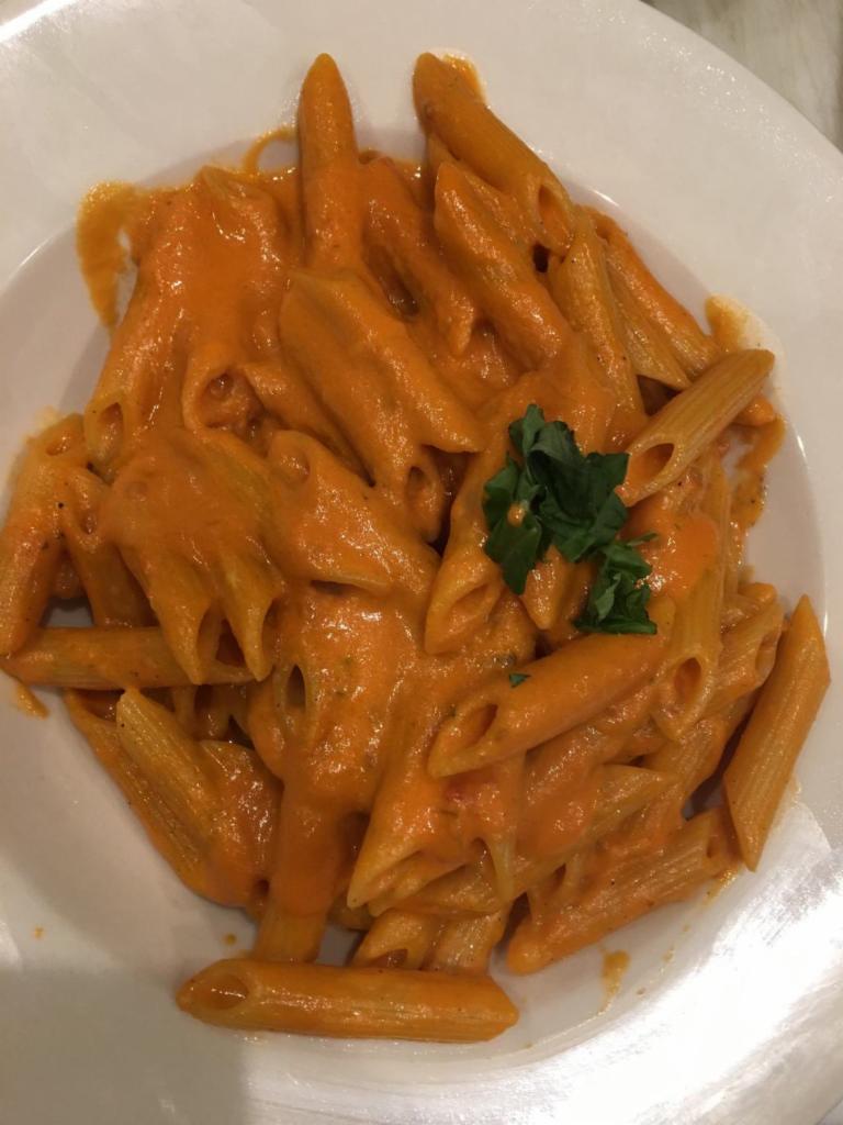 Penne alla Vodka - Large Order · Penne pasta sautéed with shallots, touch of tomatoes in a pink vodka cream sauce. Pasta served with bread.