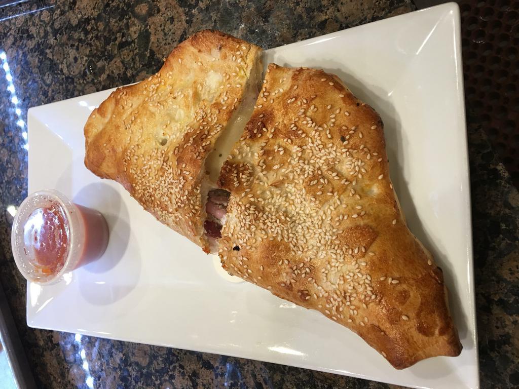 Calzone, Cheese Calzone - Served with Sauce · Pizza dough pockets, filled with seasoned whole milk ricotta and mozzarella.