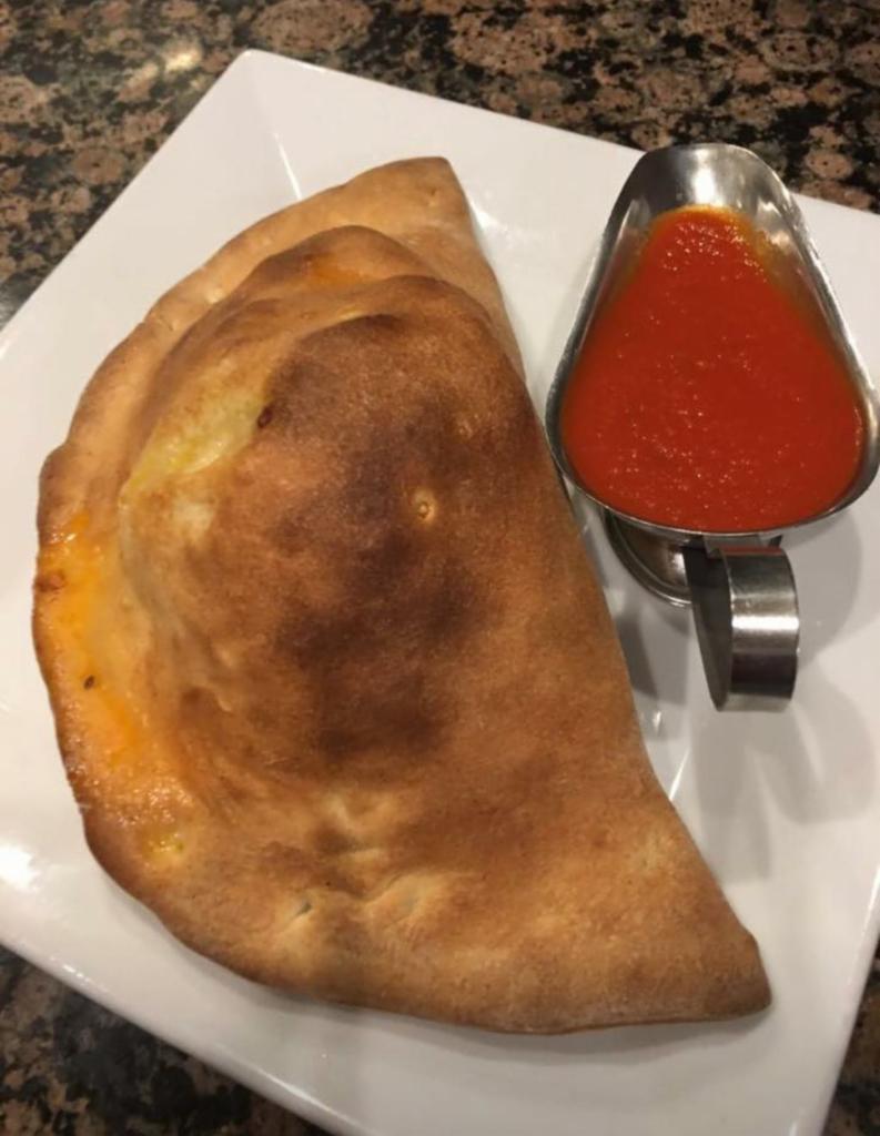 Calzone with Sausage - Served with Sauce · Calzone with Sausage, pizza dough pocket filled with seasoned whole milk ricotta and mozzarella.
