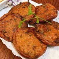 Tod Mun Pla · Thai fish cake made with red curry cilantro, coriander, egg and lime juice served with a swe...