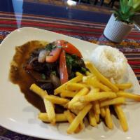 Saltados  · Sauteed sirloin beef over flames with red onions and tomatoes, served over the house fries w...