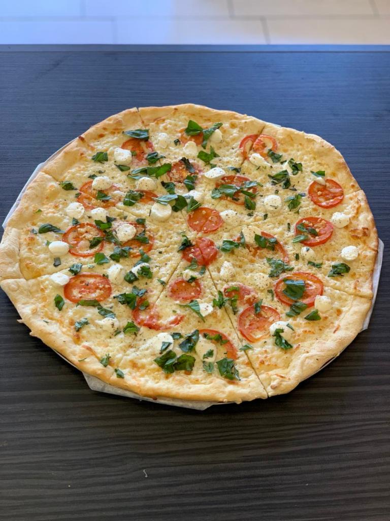 Margherita Pizza · Fresh Roma tomato, basil, Buffalo mozzarella with fresh garlic olive oil.
