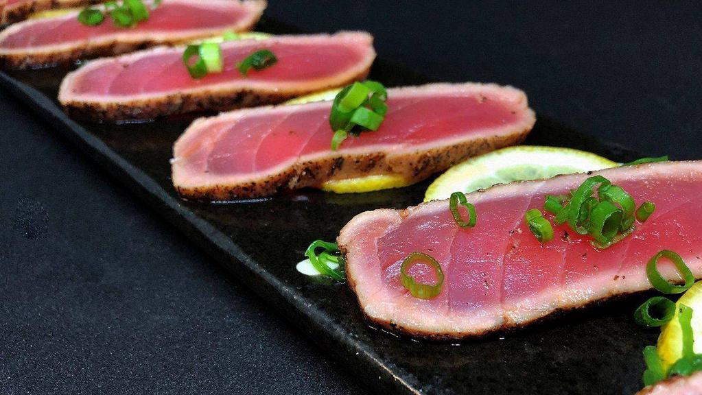 Blackened Tuna App · 10 pieces of lightly seared black pepper coated tuna drizzled with a delicious citrus ponzu sauce.