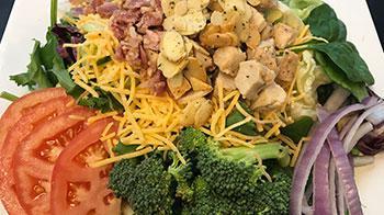 Chicken Club Salad · A blend of romaine and spinach topped with tomatoes, red onions, broccoli, chicken, smoked b...