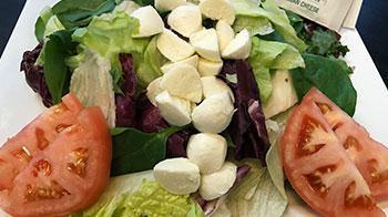 Tuscan Salad · A blend of romaine and spinach topped with tomatoes, fresh mozzarella and a side of Parmesan...