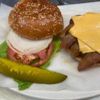 bacon cheese burger. · 1/2 pound 100% beef with american cheese, two slices bacon, garnish on a seeded bun.