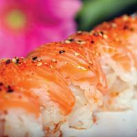 Pink Lady Roll · Spicy scallops and cucumber wrapped in soy paper, topped with salmon and spicy sauce.