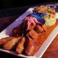 Chochinita Pibil · Achiote marinated roasted pork served with green rice, nopales, and moduros.