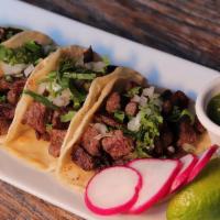 Tacos al Carbon · Grilled skirt steak tacos, topped with white onions, cilantro, radish and salsa borracha.