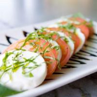 Caprese Salad · Slices of fresh mozzarella cheese, tomatoes, Julienne basil and topped with a balsamic reduc...