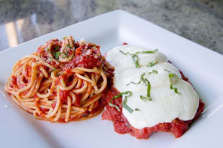 Chicken Parmesan · A lightly breaded chicken breast fried then topped and baked with marinara sauce and mozzarella cheese. Served with spaghetti marinara.