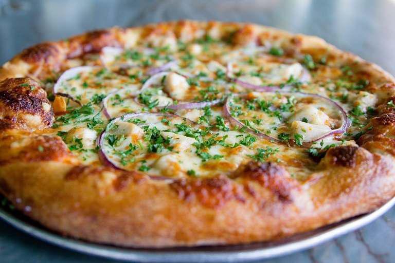 BBQ Chicken Pizza · Roasted chicken, sliced red onions, cilantro, Gouda cheese and BBQ sauce.