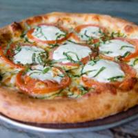 Margherita Pizza · Fresh sliced tomatoes, house-made fresh mozzarella, roasted garlic, fresh basil, with a herb...
