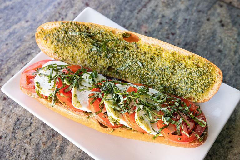 Caprese Sub Sandwich · Fresh tomatoes and fresh mozzarella cheese,  pesto sauce, layered and topped with fresh basil and olive oil.