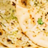 Garlic Naan · Plain bread baked in a clay oven sprinkled with garlic and cilantro.