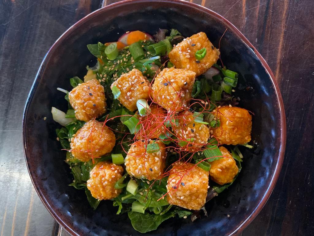 Sweet Chile Tofu · Marinated fried tofu tossed in a sweet chili glaze served over a bed of greens.

