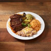 Carne a la Parilla · Grilled steak in a bed of grilled onions topped with chile Anaheim and side of guacamole.